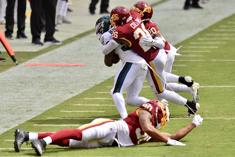 Members of The Washington Football Team tackle a Philadelphia Eagles player